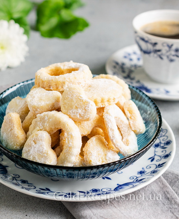 Печиво на смальці в цукровій пудрі, до чаю в керамічній чашці з квітковим візерунком